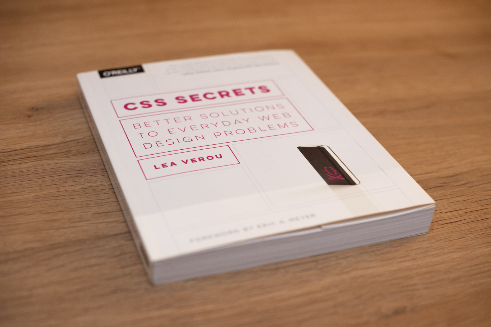 A photo of the CSS Secrets book, closed, on a wooden surface